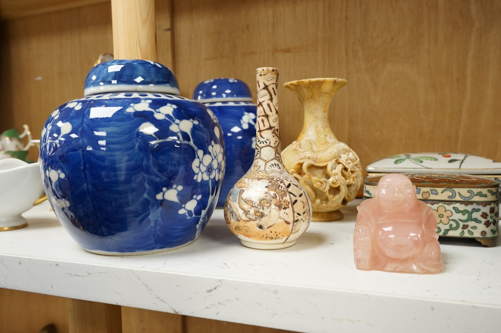A group of mixed Chinese and Japanese ceramics to include soapstone carvings, prunus flower ginger jars, rose quartz Buddha and pair of famille rose bowls. Condition - varies, mostly fair/good